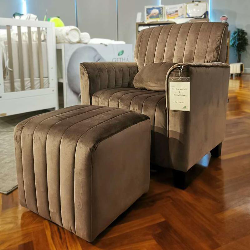 Getha Relax armchair and ottoman set in a living room. This modern gray fabric chair features a headrest and armrests for ultimate comfort.